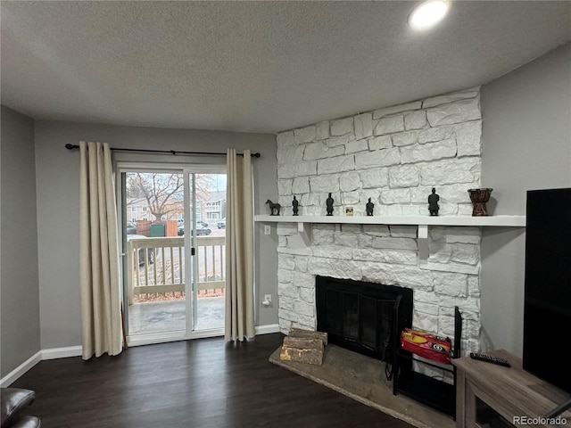 living room with a fireplace, a textured ceiling, and dark hardwood / wood-style flooring