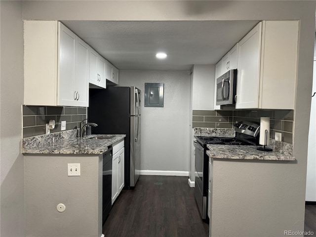 kitchen featuring decorative backsplash, appliances with stainless steel finishes, white cabinetry, and dark wood-type flooring