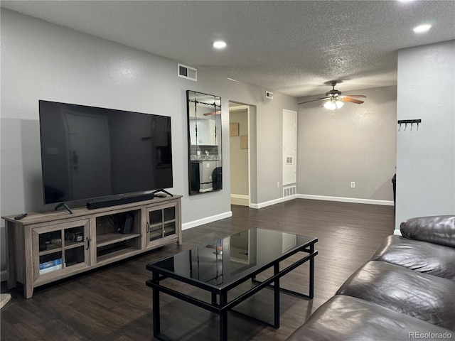 living room with dark hardwood / wood-style floors, ceiling fan, and a textured ceiling