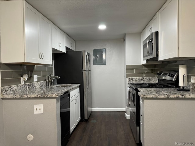 kitchen featuring white cabinets, light stone counters, stainless steel appliances, and tasteful backsplash