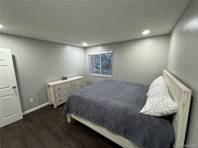 bedroom with a textured ceiling and dark hardwood / wood-style floors