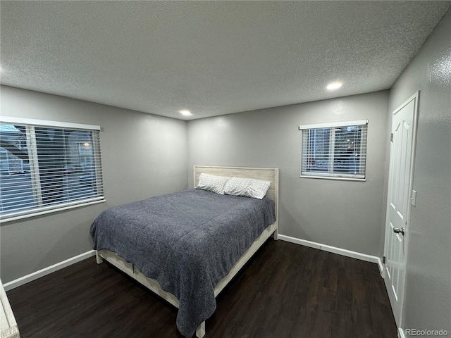 bedroom featuring a textured ceiling and dark hardwood / wood-style floors