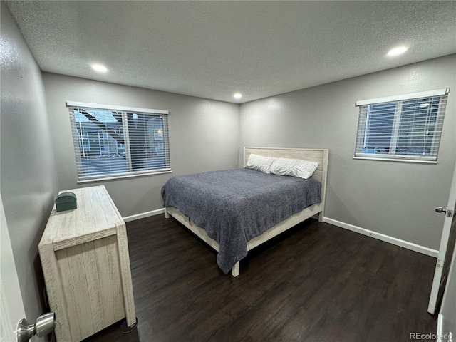 bedroom with a textured ceiling and dark hardwood / wood-style flooring