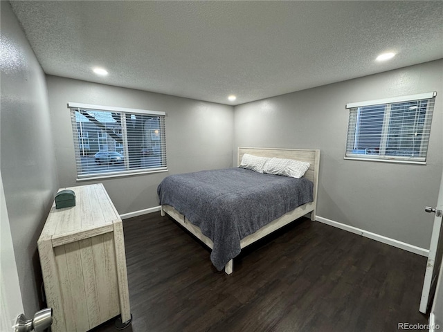 bedroom with dark hardwood / wood-style flooring and a textured ceiling