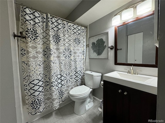 bathroom featuring tile patterned flooring, vanity, curtained shower, and toilet