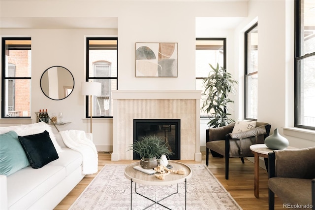 living area featuring a tile fireplace and light wood-style floors