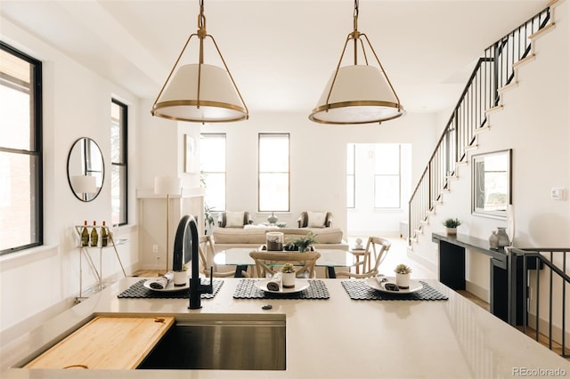 kitchen featuring hanging light fixtures, light countertops, a sink, and open floor plan