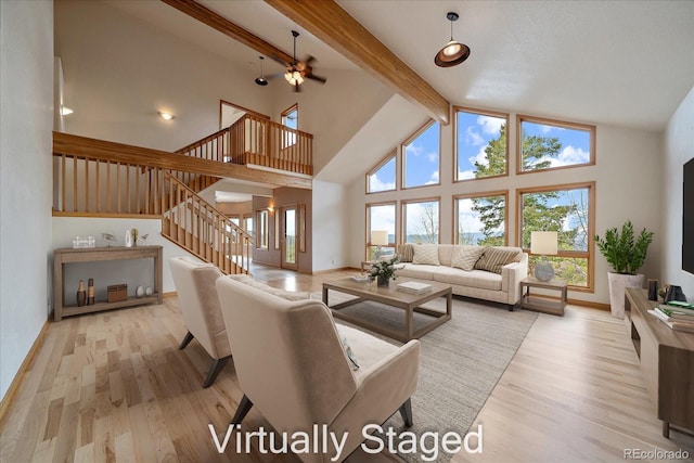 23007 Big Game Trl, Conifer, CO 80433 - living room with stairs, beamed ceiling, light wood-style floors, healthy amount of natural light, and baseboards