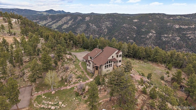 23007 Big Game Trl, Conifer, CO 80433 - aerial overview of property's location with a heavily wooded area and a mountain backdrop