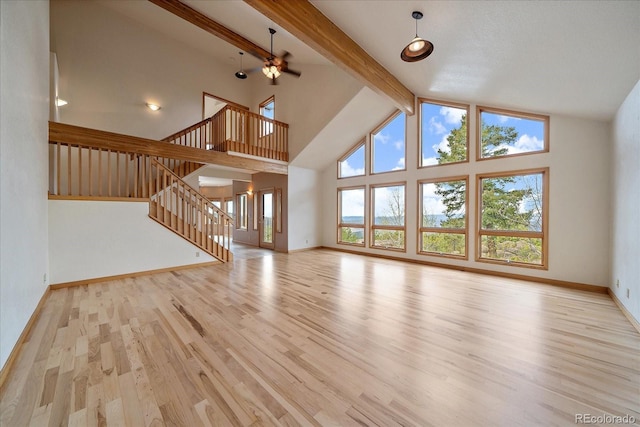 23007 Big Game Trl, Conifer, CO 80433 - unfurnished living room with beamed ceiling, light wood-type flooring, stairway, baseboards, and high vaulted ceiling