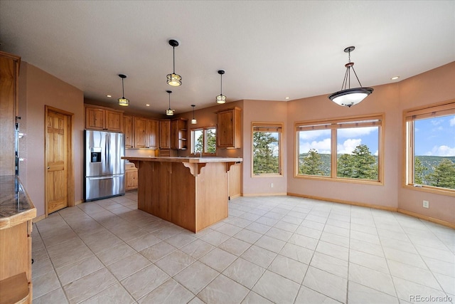 23007 Big Game Trl, Conifer, CO 80433 - kitchen with stainless steel fridge, healthy amount of natural light, a breakfast bar area, light tile patterned floors, and recessed lighting