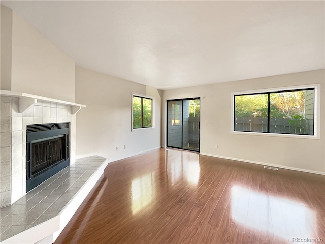 unfurnished living room featuring a fireplace and dark hardwood / wood-style floors