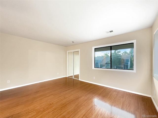 empty room with hardwood / wood-style flooring