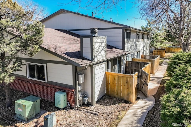 15157 E Louisiana Dr Unit A, Aurora, CO 80012 - view of side of property with a shingled roof and brick siding