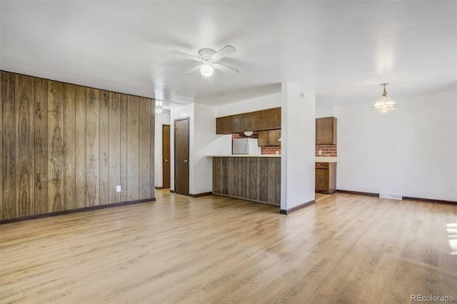 15157 E Louisiana Dr Unit A, Aurora, CO 80012 - unfurnished living room featuring wood walls, light wood-style floors, and a ceiling fan