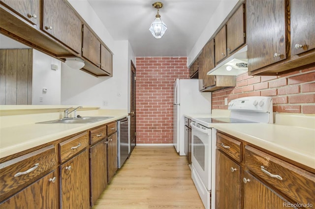 15157 E Louisiana Dr Unit A, Aurora, CO 80012 - kitchen featuring brick wall, white appliances, under cabinet range hood, light wood-style floors, and light countertops