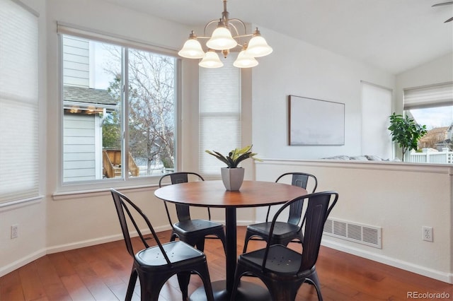 dining room featuring wood finished floors, visible vents, and baseboards