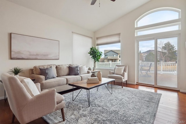 living area featuring high vaulted ceiling, a ceiling fan, and wood finished floors