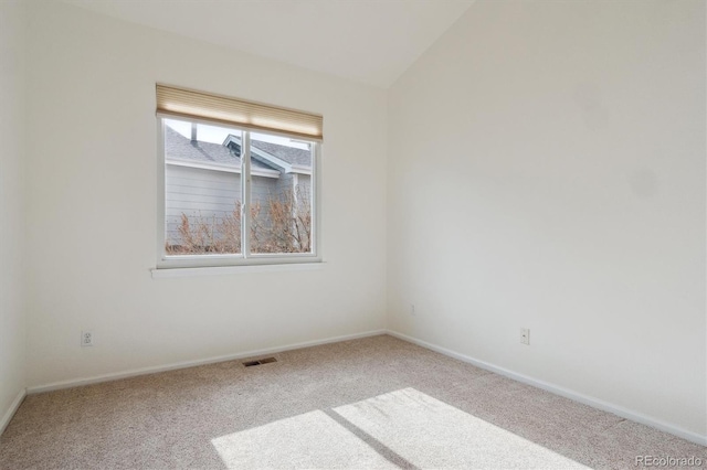 unfurnished room with lofted ceiling, carpet, visible vents, and baseboards