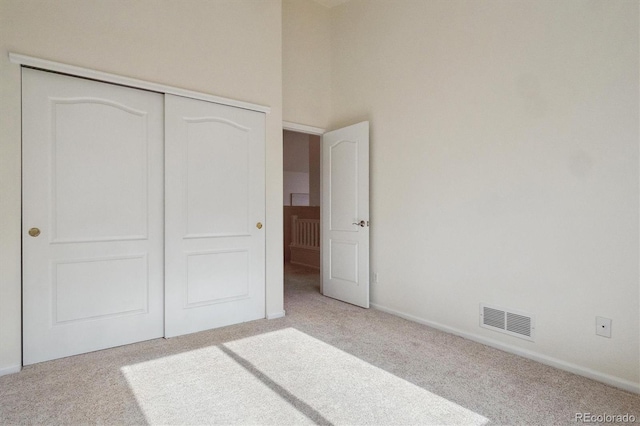 unfurnished bedroom with a closet, visible vents, and carpet flooring