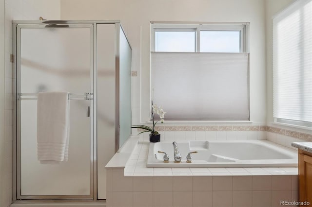 bathroom with a shower stall, a bath, and vanity