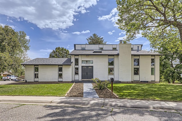 7792 Garrison Ct, Arvada, CO 80005 - view of front of home with a front lawn, a chimney, and roof with shingles