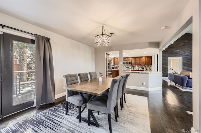 7792 Garrison Ct, Arvada, CO 80005 - dining area featuring a chandelier, dark wood-style flooring, and baseboards
