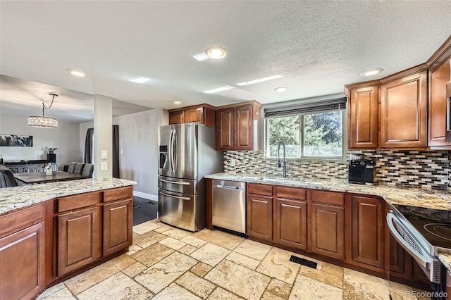 7792 Garrison Ct, Arvada, CO 80005 - kitchen featuring stainless steel appliances, decorative backsplash, recessed lighting, stone tile floors, and a sink