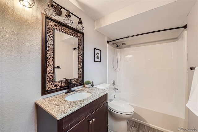 7792 Garrison Ct, Arvada, CO 80005 - full bath with washtub / shower combination, a textured wall, vanity, toilet, and wood finished floors