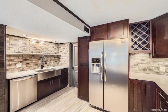 7792 Garrison Ct, Arvada, CO 80005 - kitchen with appliances with stainless steel finishes, a sink, backsplash, light countertops, and light wood-style flooring