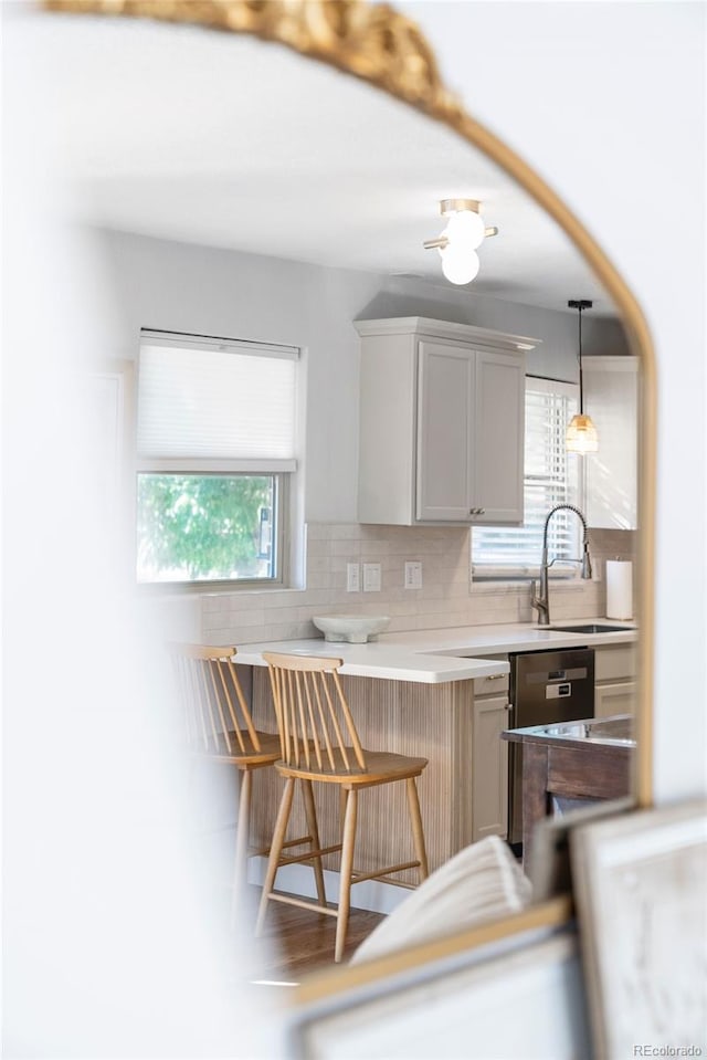 kitchen featuring plenty of natural light, a kitchen bar, sink, and decorative backsplash