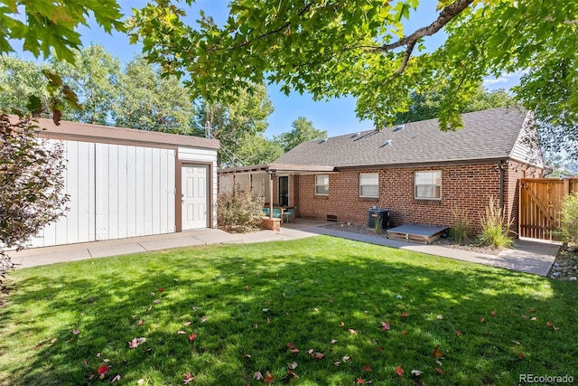 back of property featuring cooling unit, a yard, and an outbuilding