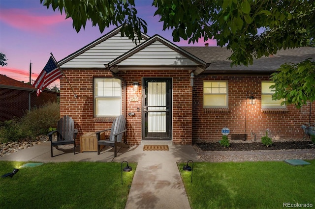 view of front of home with a yard and a patio area