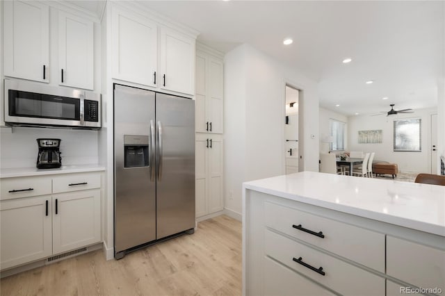 kitchen featuring stainless steel appliances, recessed lighting, visible vents, white cabinetry, and light wood-type flooring