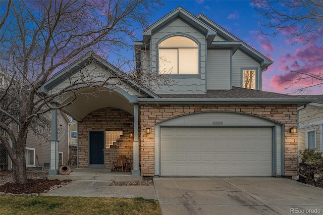 traditional-style house with stone siding and driveway