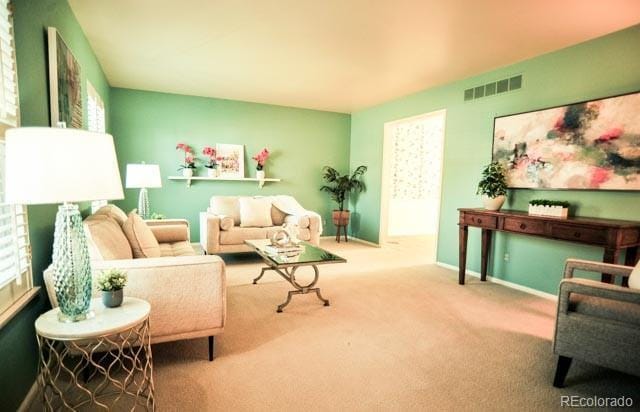 carpeted living room featuring visible vents and baseboards