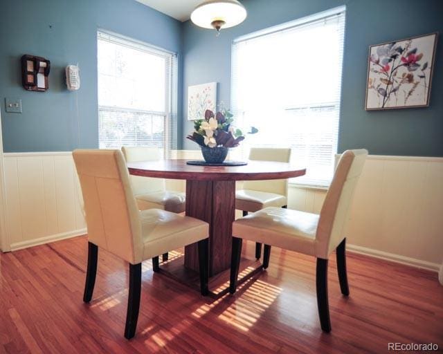 dining area featuring a wainscoted wall and wood finished floors