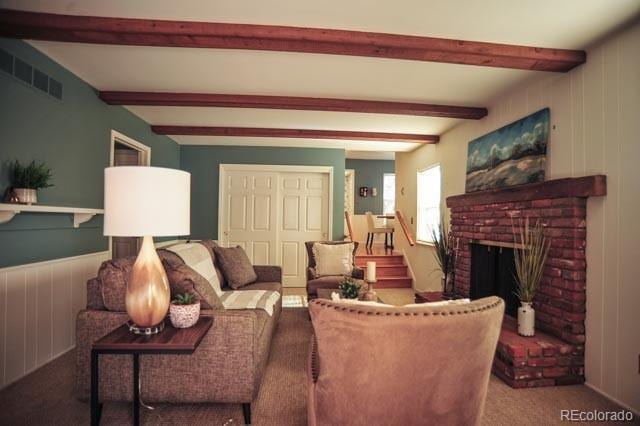 living room with beamed ceiling, carpet flooring, a fireplace, and visible vents