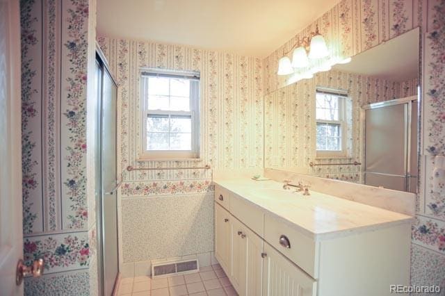 full bath with wallpapered walls, a healthy amount of sunlight, and visible vents