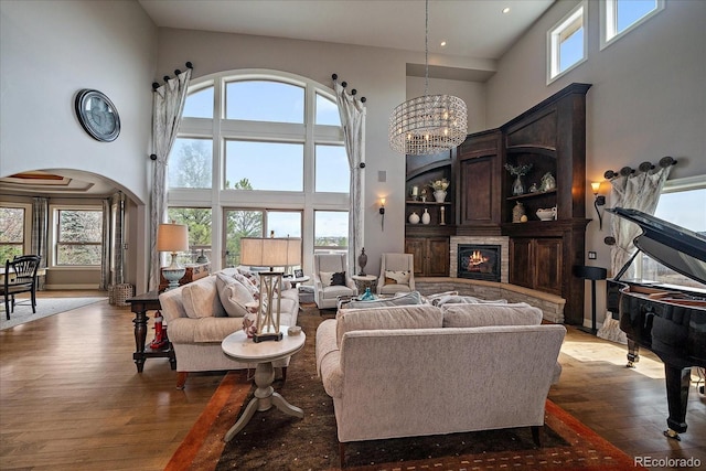 living room featuring a high ceiling, plenty of natural light, and wood finished floors