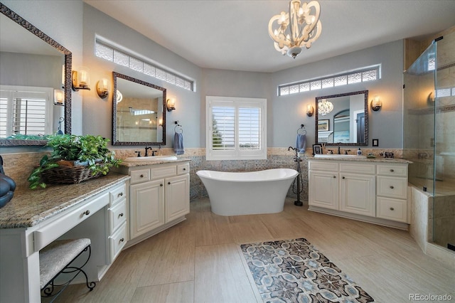 bathroom featuring a sink, tile walls, a freestanding bath, a notable chandelier, and tiled shower