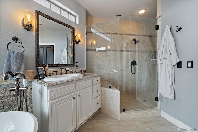 bathroom with a freestanding bath, vanity, and a shower stall