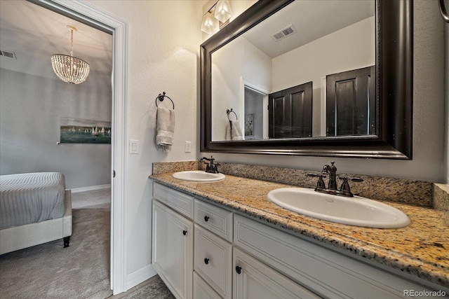 bathroom featuring a sink, double vanity, a notable chandelier, and visible vents