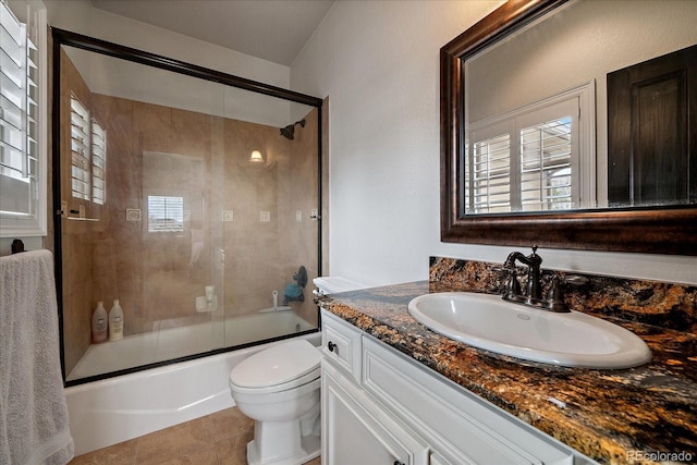 full bath featuring toilet, tile patterned floors, vanity, and shower / bath combination with glass door