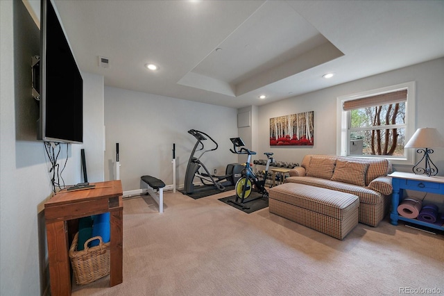 workout room with a tray ceiling, carpet, visible vents, and recessed lighting