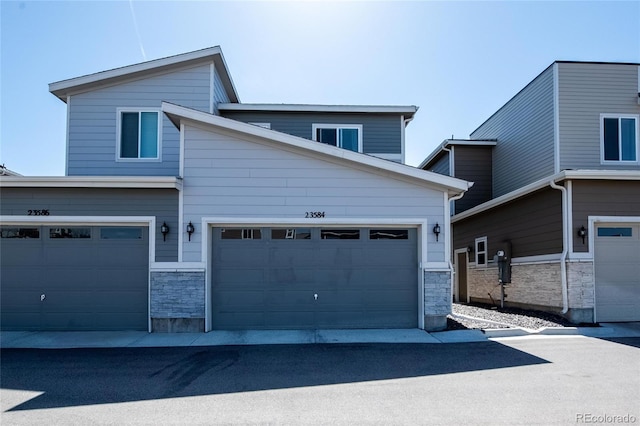 23584 E 5th Pl, Aurora, CO 80018 - view of front of property featuring stone siding and a garage