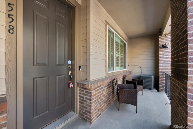 doorway to property with brick siding and a porch