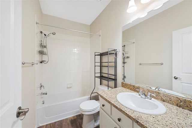 bathroom featuring washtub / shower combination, toilet, vanity, and wood finished floors