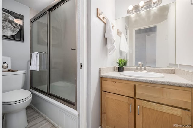 full bathroom featuring vanity, shower / bath combination with glass door, and toilet