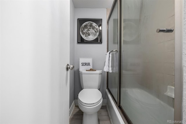 bathroom with a shower with shower door and toilet